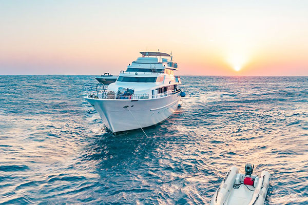 Scuba divers preparing for a dive from a liveaboard yacht in Egypt’s Red Sea under clear blue skies.