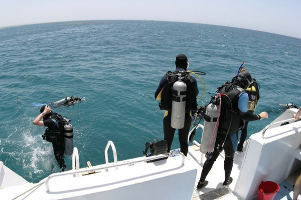 Scuba diver preparing for a dive on a Red Sea liveaboard, ensuring safety and health protocols during a diving trip in Egypt.